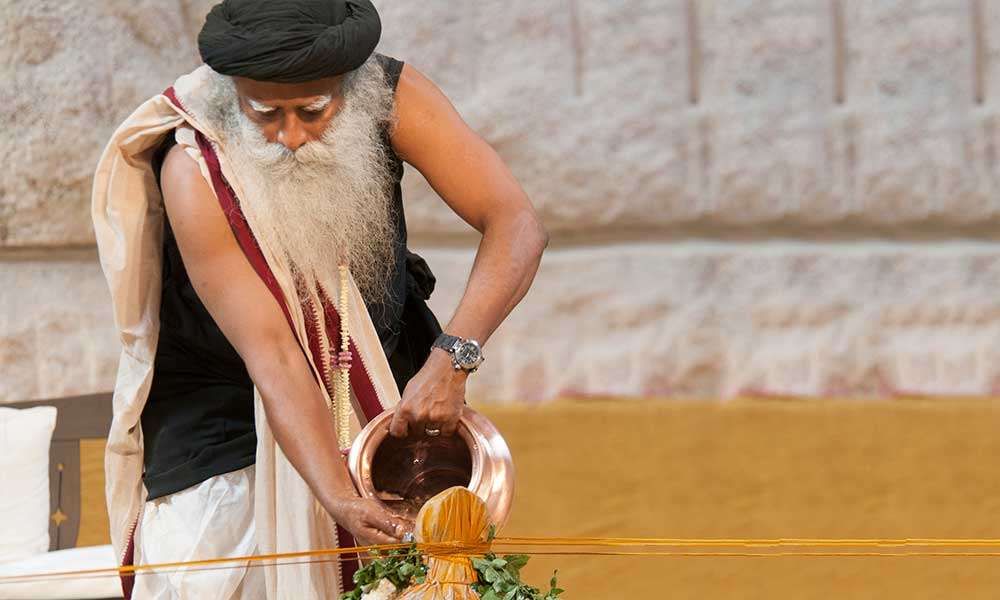 Close up of Sadhguru pouring water over a linga.